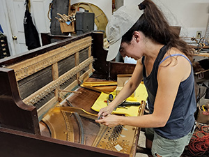 woman restoring piano